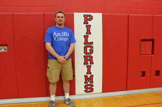 Garrett Tharp standing next to Pilgrims sign.