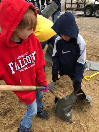 Two students filling sandbags- Ava Nelson (Webster Elementary School - 2nd Grade) and  Joel Nelson (Webster Elementary School - Kindergarten) 