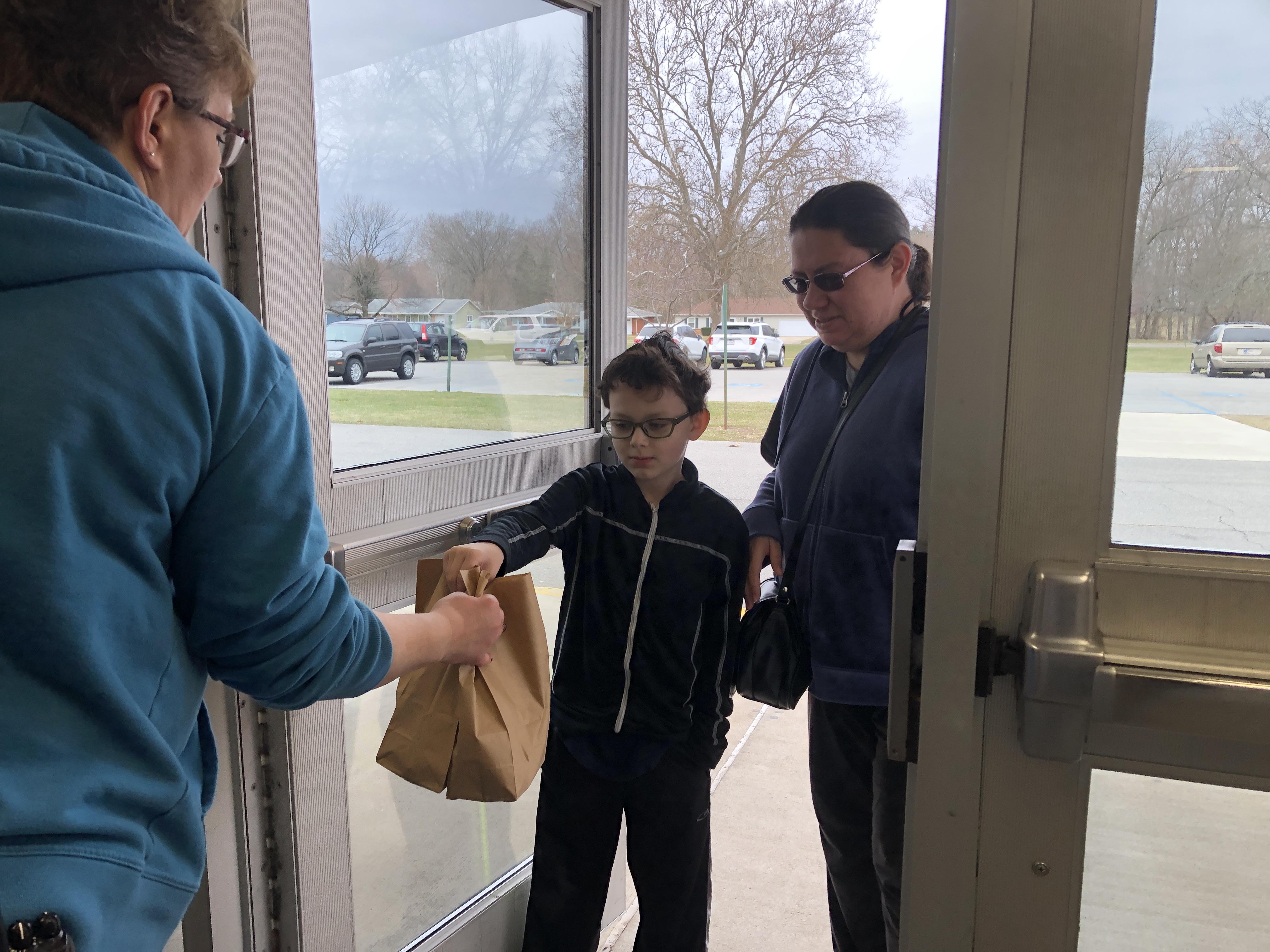 2nd Grade Jefferson Elementary School student Tristan Cerrato and his mom Crystal stop by PHS to pick up lunch. ammy Southern, the head cook at PHS prepared close to 220 sack lunches for the Plymouth High School location.