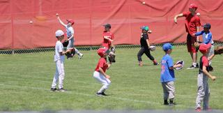 Kids playing catch on baseball field