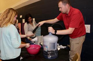 Riverside Teacher Eric Knebel with science fair guests making bubbles.